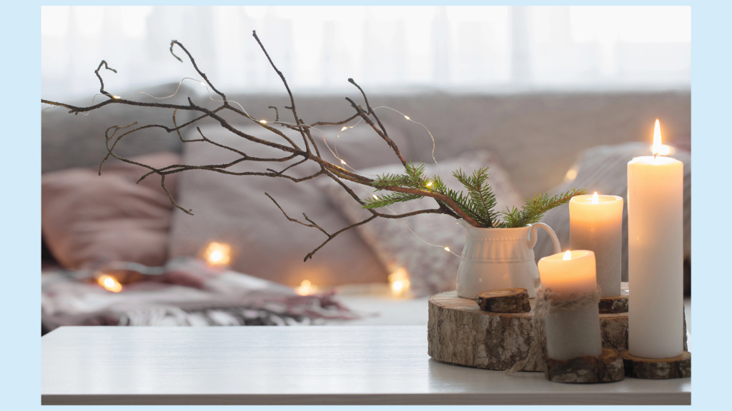Cozy winter home décor with candles, greenery, and neutral layered textures for a natural seasonal look.