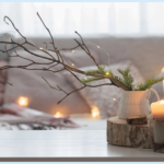 Cozy winter home décor with candles, greenery, and neutral layered textures for a natural seasonal look.