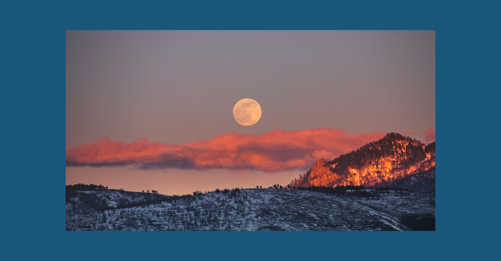 Full Snow Moon rising over a snowy winter landscape, symbolizing February’s ancestral wisdom and storytelling traditions.