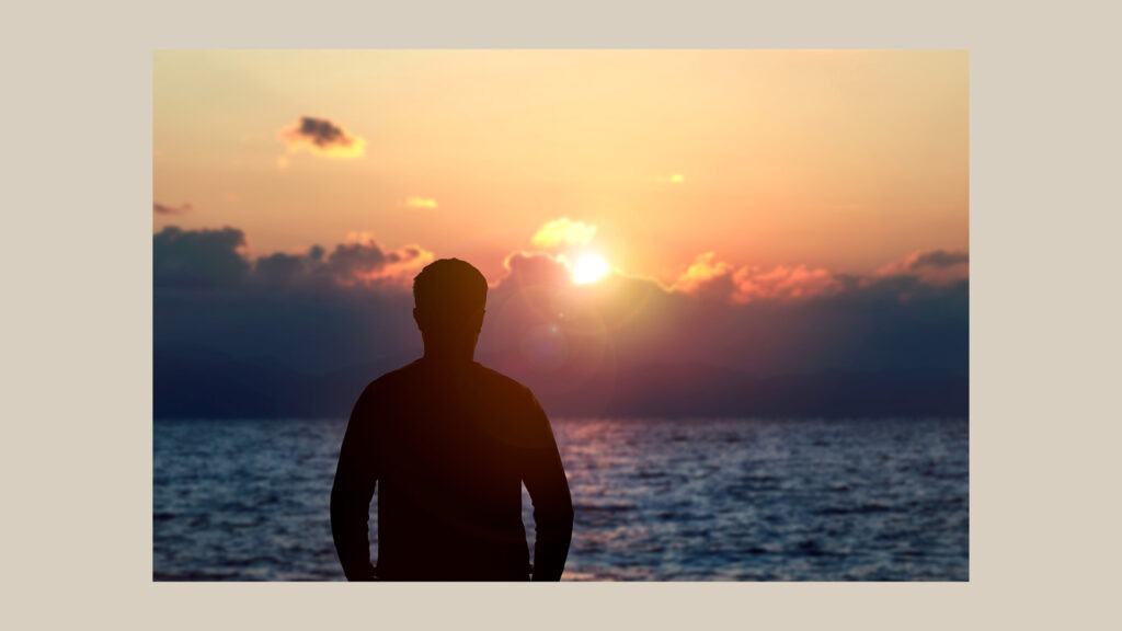 Divine masculine Beltane symbolism with a man standing before the sunset.